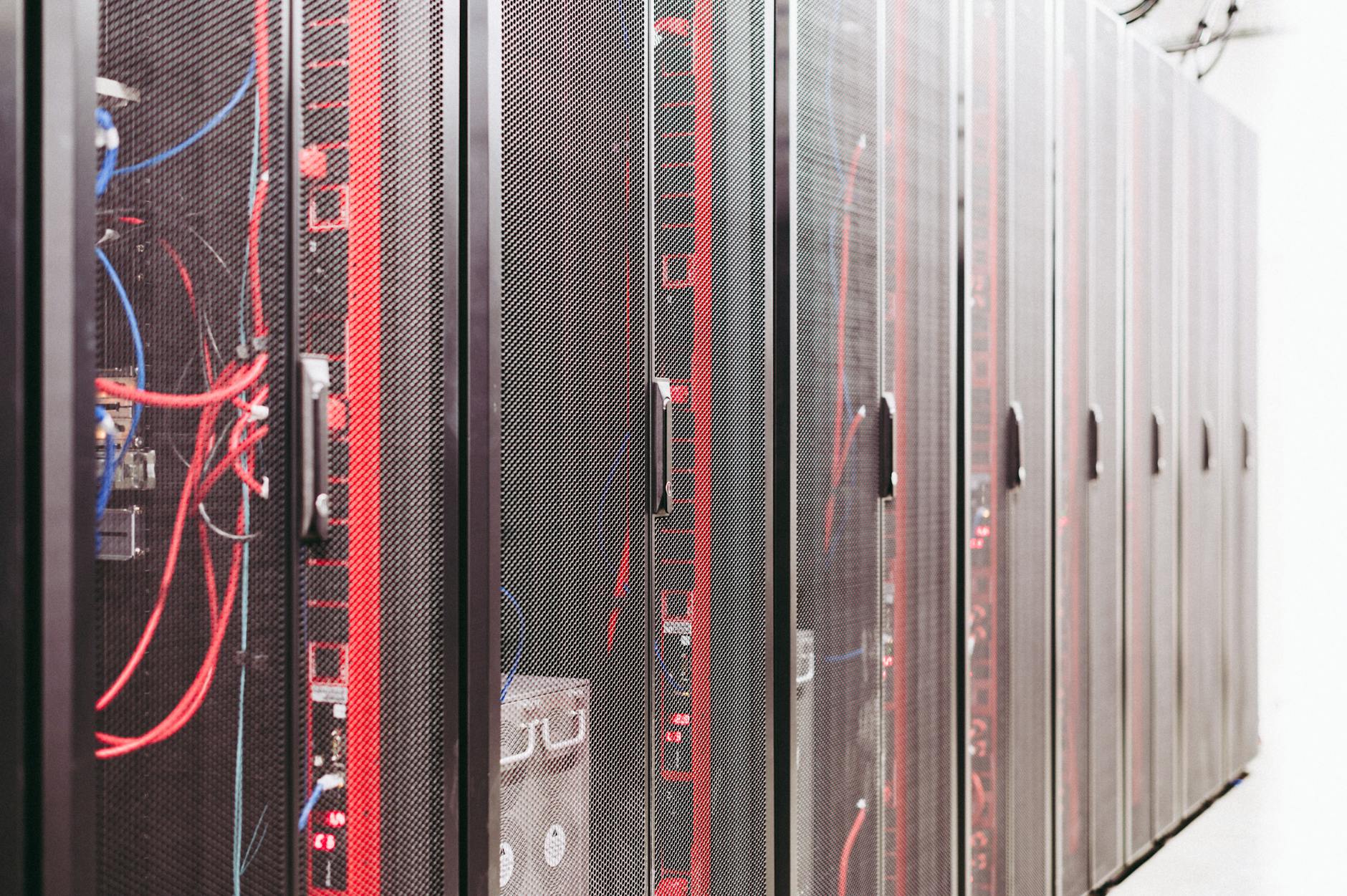 Rows of servers inside a large data center facility with blue lighting
