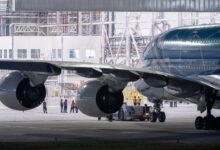 Aircraft technician performing maintenance work on a commercial airplane engine in a hangar