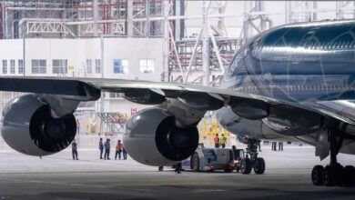 Aircraft technician performing maintenance work on a commercial airplane engine in a hangar
