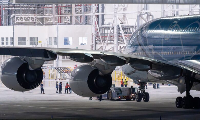 Aircraft technician performing maintenance work on a commercial airplane engine in a hangar