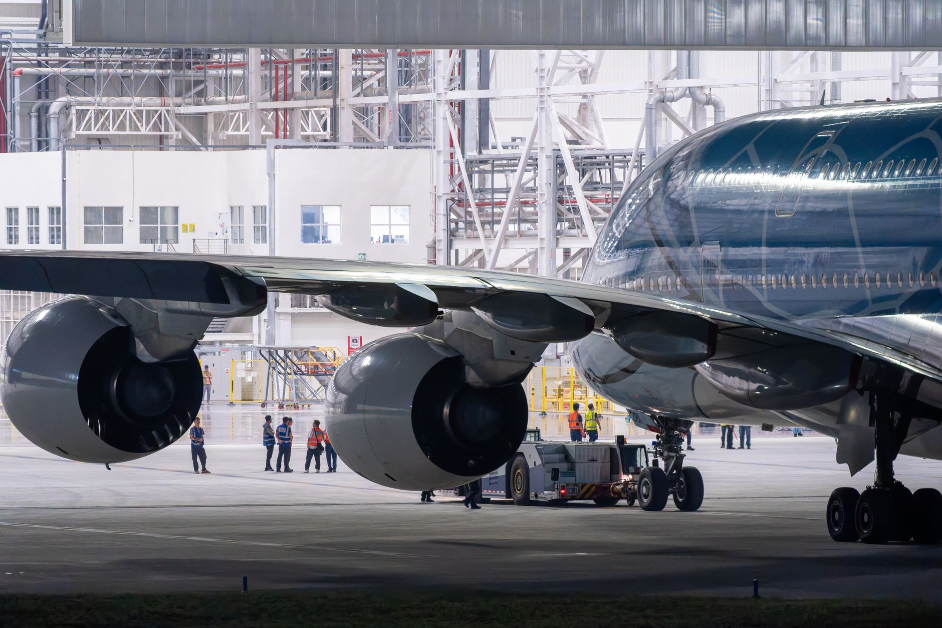 Aircraft technician performing maintenance work on a commercial airplane engine in a hangar