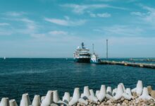 Large liquefied natural gas terminal with storage tanks along a coastal industrial waterfront
