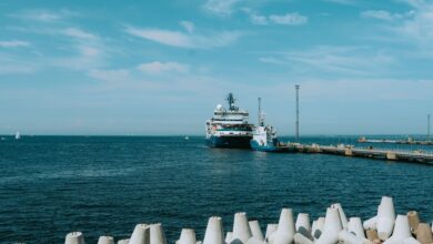 Large liquefied natural gas terminal with storage tanks along a coastal industrial waterfront