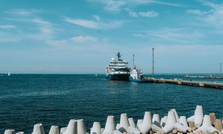 Large liquefied natural gas terminal with storage tanks along a coastal industrial waterfront