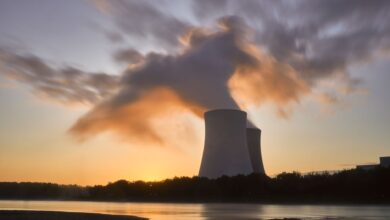 Aerial view of a nuclear power plant with cooling towers beside a river