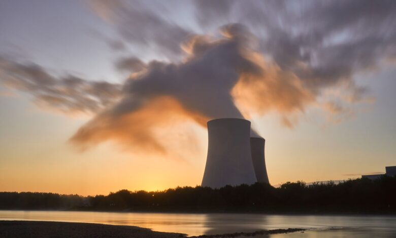 Aerial view of a nuclear power plant with cooling towers beside a river