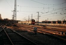 Long freight train moving through open countryside representing railroad infrastructure investment