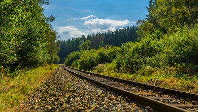 Aerial view of railroad tracks running through a rural countryside corridor