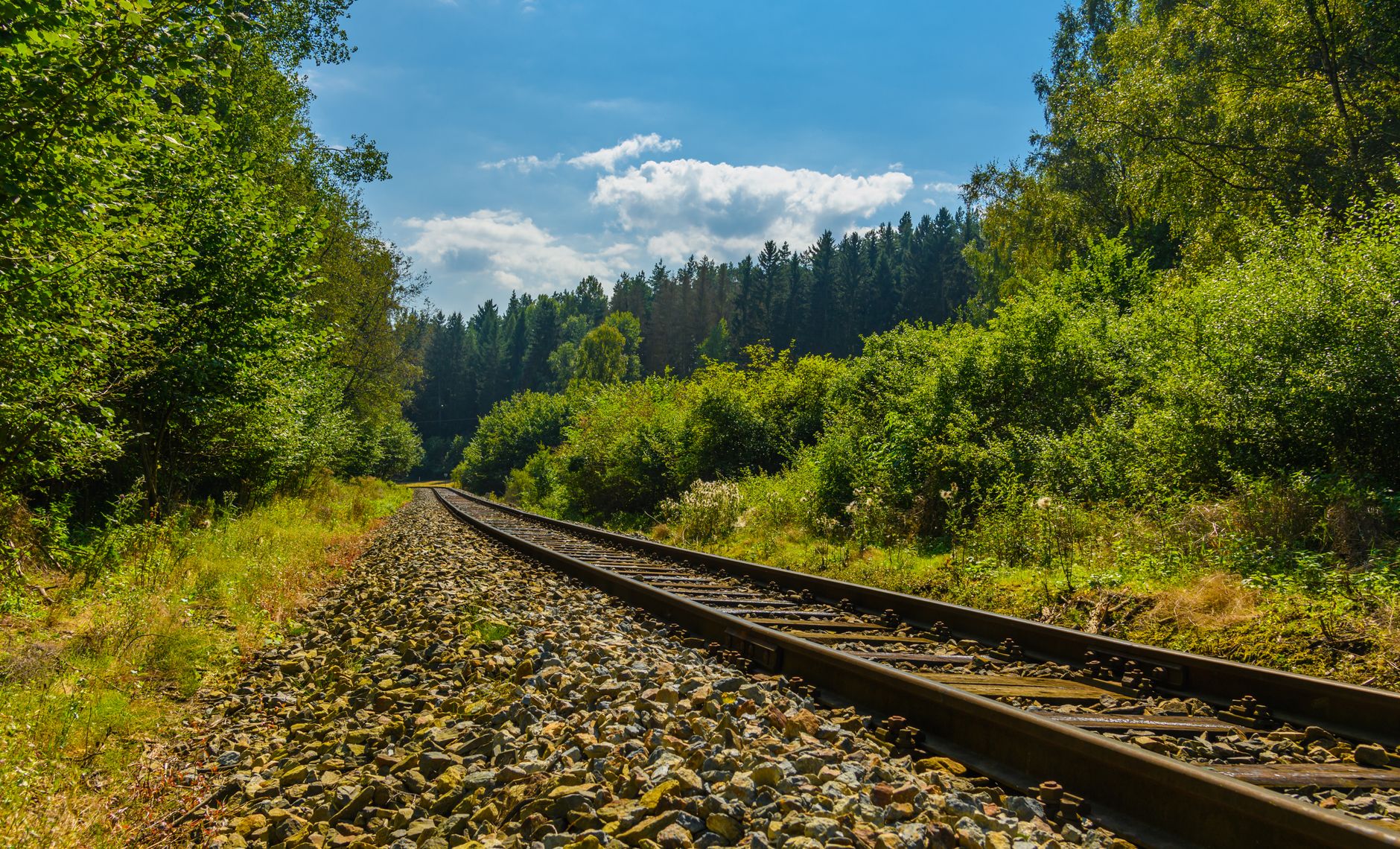 Aerial view of railroad tracks running through a rural countryside corridor