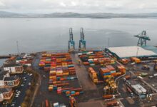 Aerial view of a large container seaport with stacked shipping containers and cranes