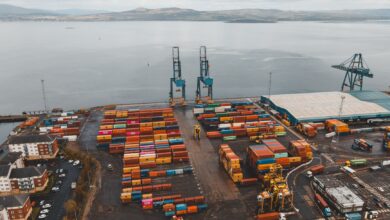 Aerial view of a large container seaport with stacked shipping containers and cranes