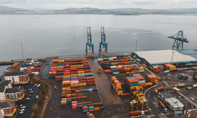 Aerial view of a large container seaport with stacked shipping containers and cranes