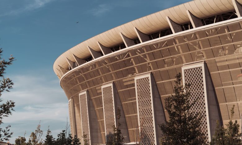 Exterior view of a large sports arena at dusk with illuminated signage