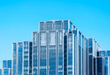 Glass office tower facade representing distressed commercial real estate at the center of CMBS market stress