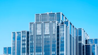 Glass office tower facade representing distressed commercial real estate at the center of CMBS market stress