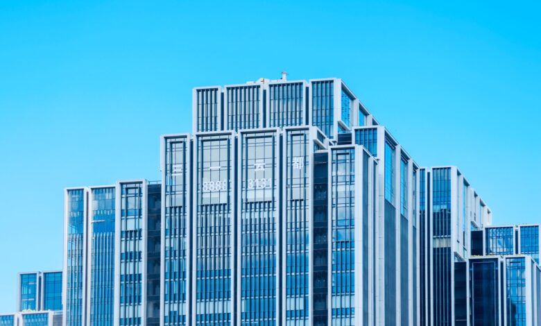 Glass office tower facade representing distressed commercial real estate at the center of CMBS market stress