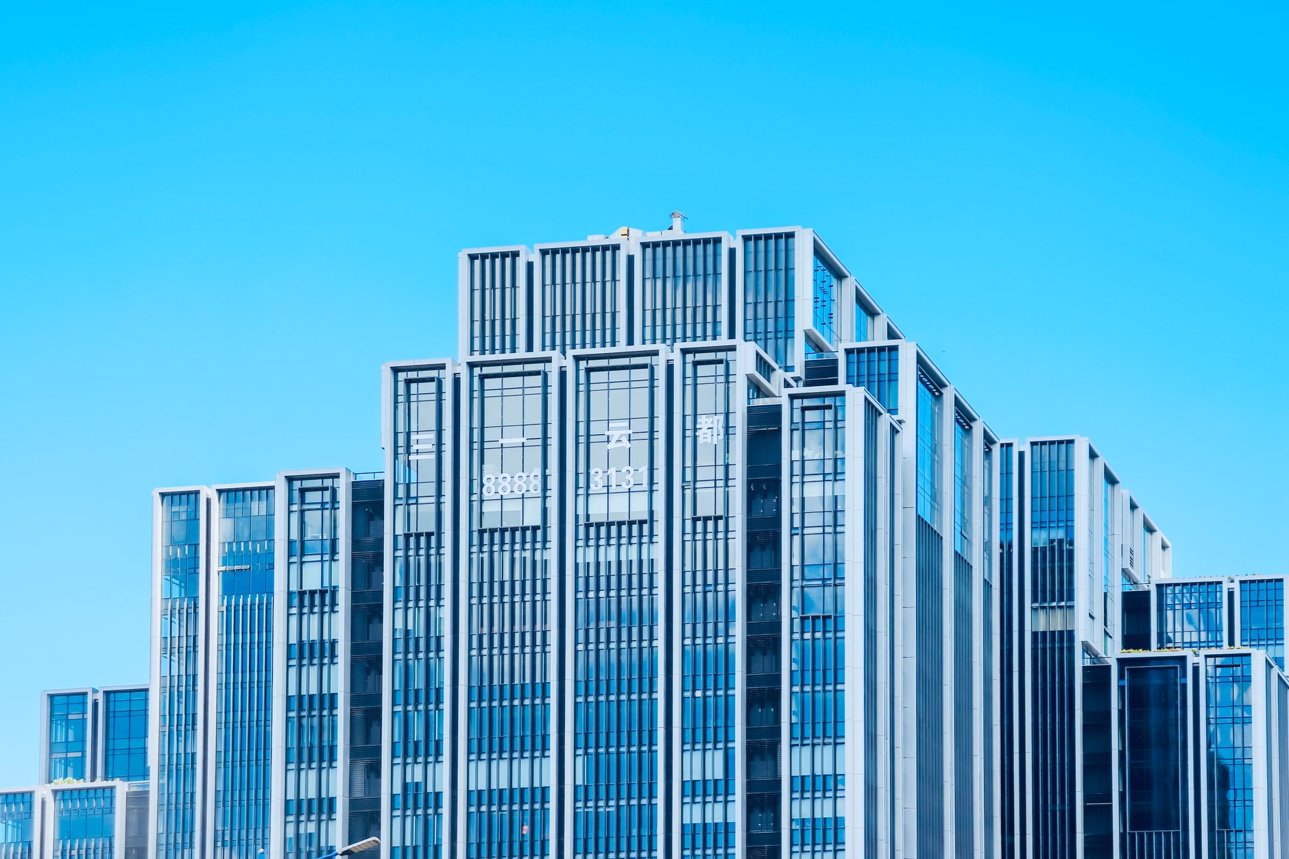Glass office tower facade representing distressed commercial real estate at the center of CMBS market stress