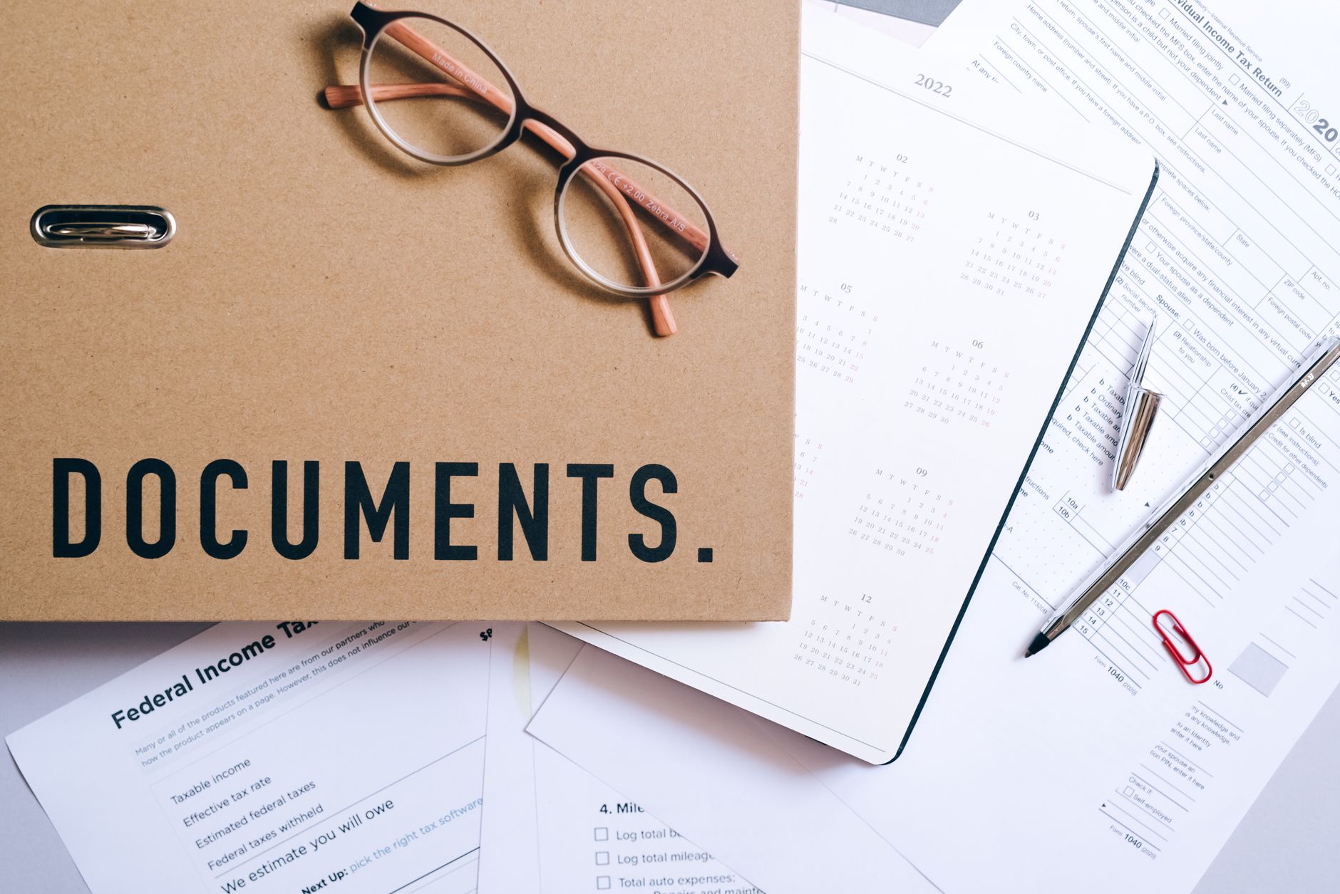 Financial analyst reviewing credit documents and spreadsheets at a desk