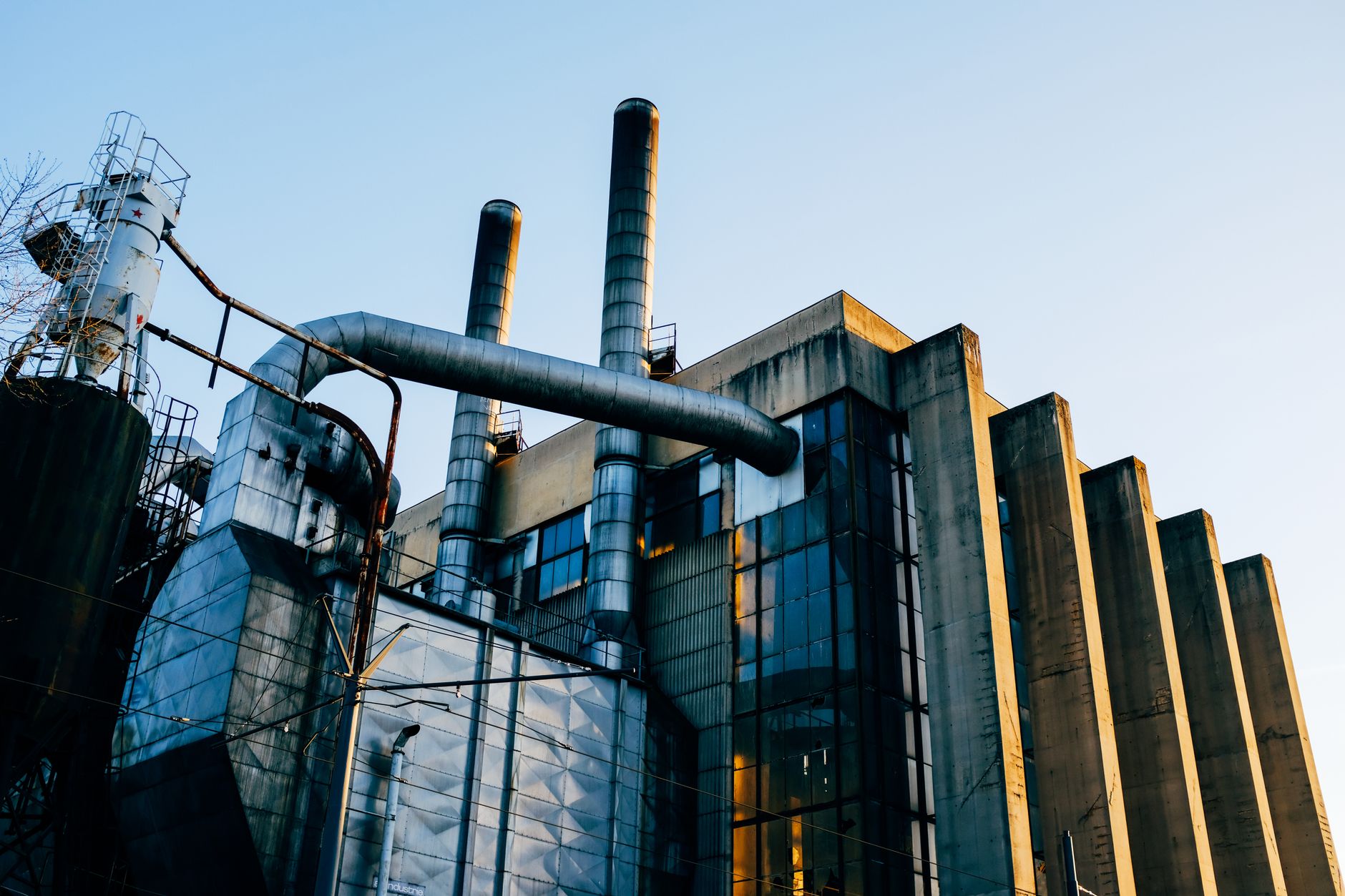 Industrial energy facility with storage tanks and processing equipment used in midstream operations