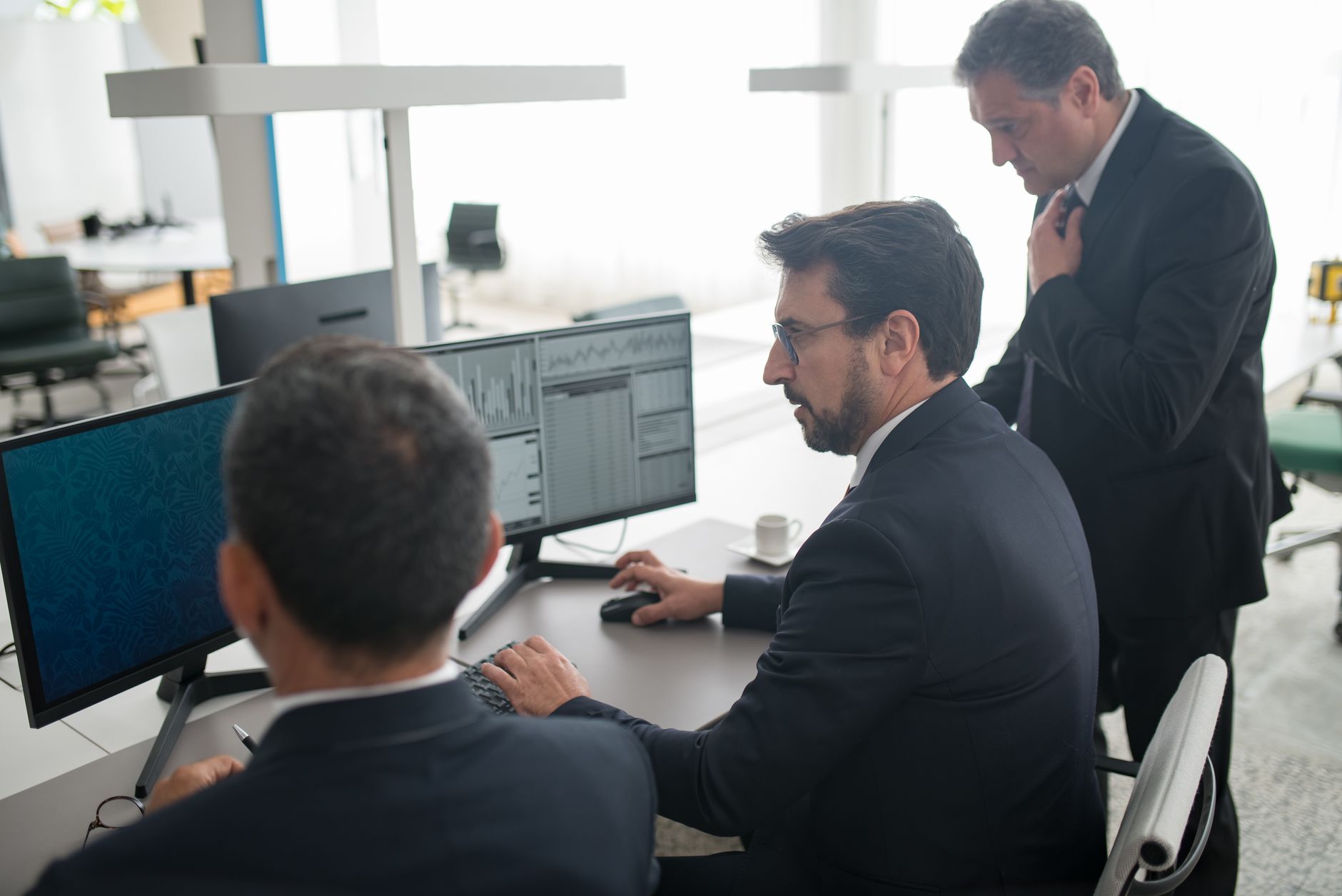 Financial traders working at a fixed-income trading desk reviewing bond data