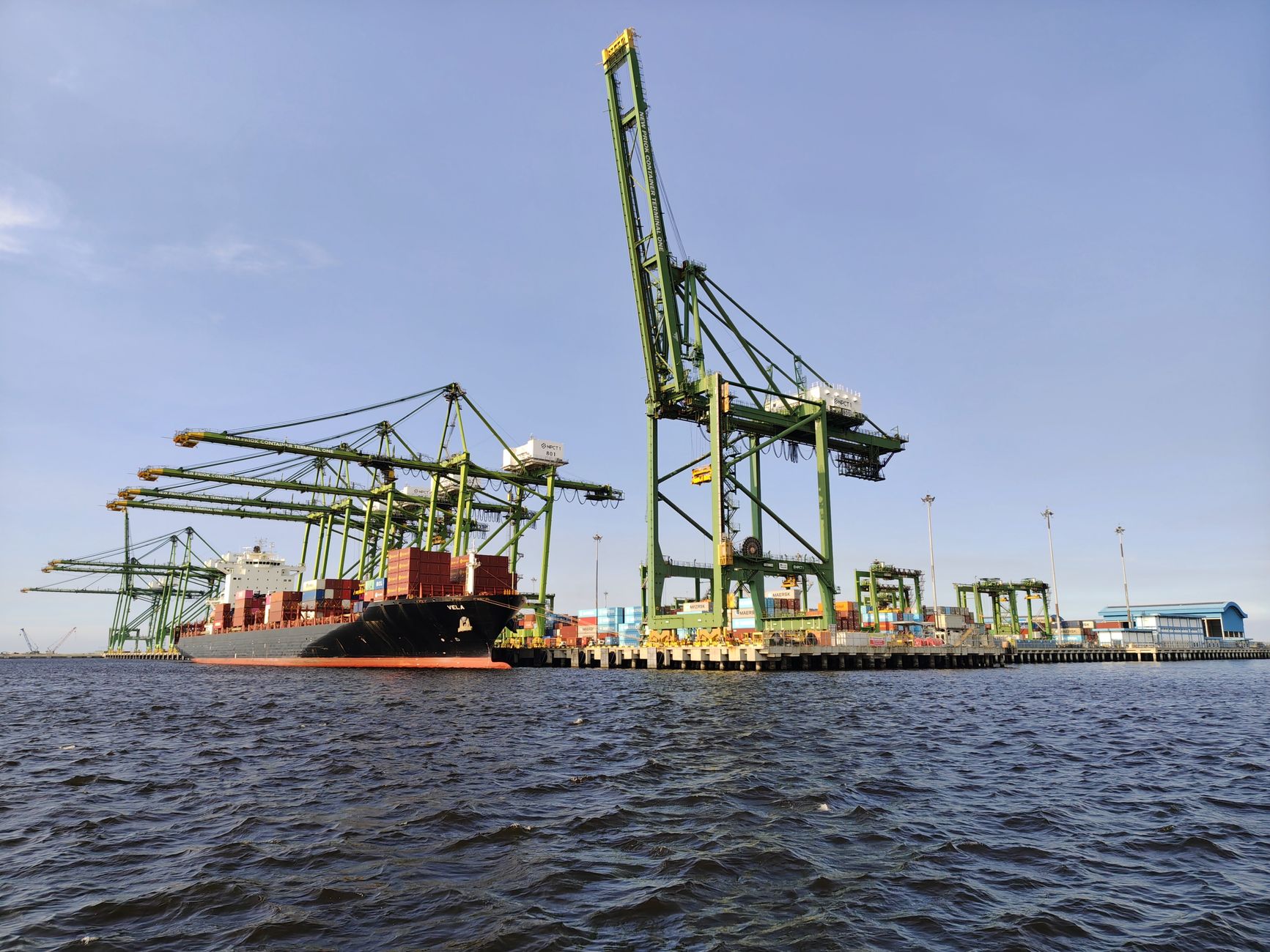 Cargo ships docked at a commercial seaport terminal with loading equipment