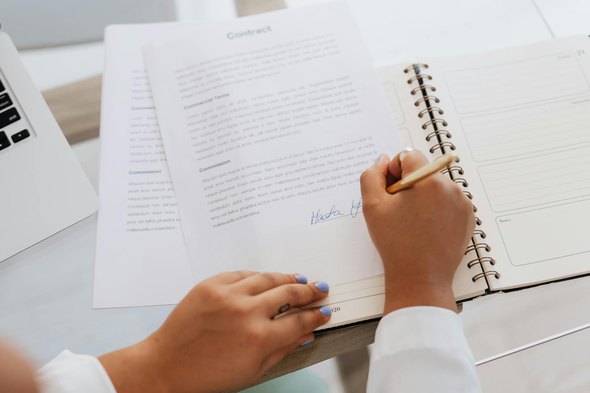 Person reviewing and signing legal documents at a desk