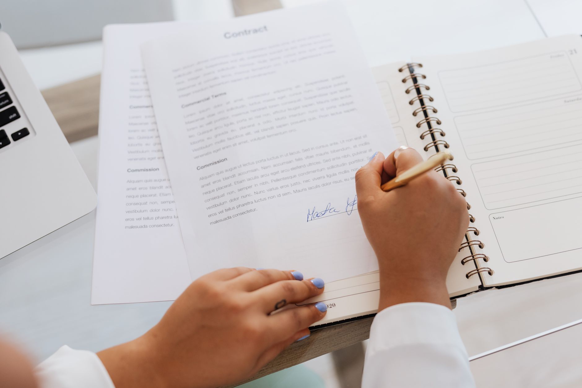 Two people reviewing and signing a financial contract at a desk