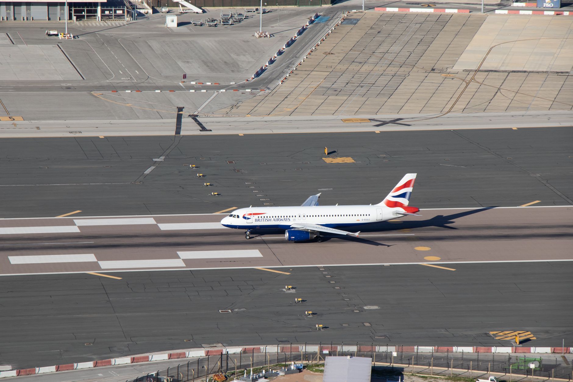Aerial view of an airport runway with aircraft lined up for departure