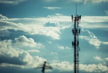 Wireless cell tower against a clear sky representing infrastructure ground lease investments