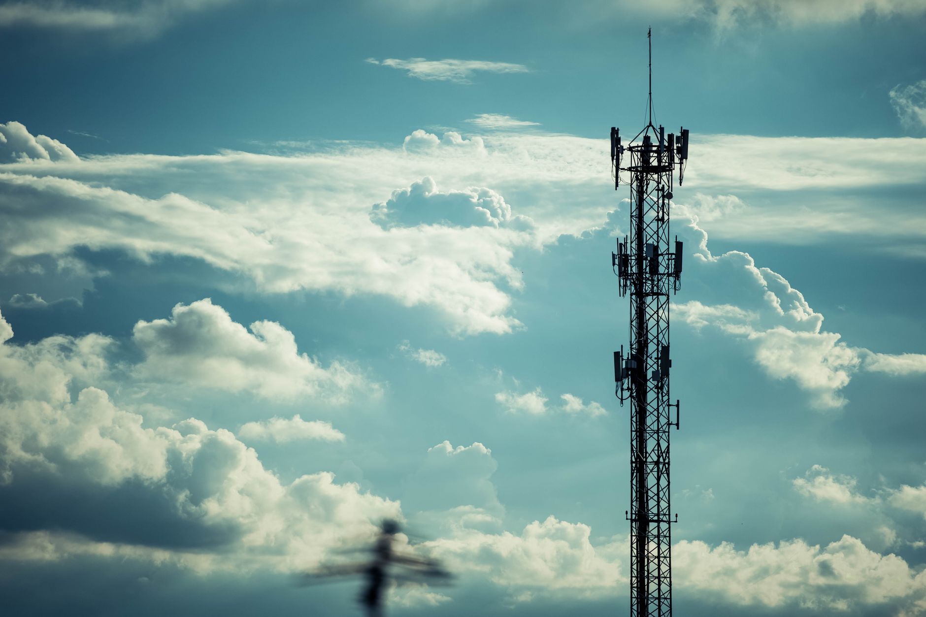 Wireless cell tower against a clear sky representing infrastructure ground lease investments