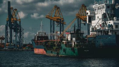 Large cargo ship docked at a commercial shipping port with stacked containers