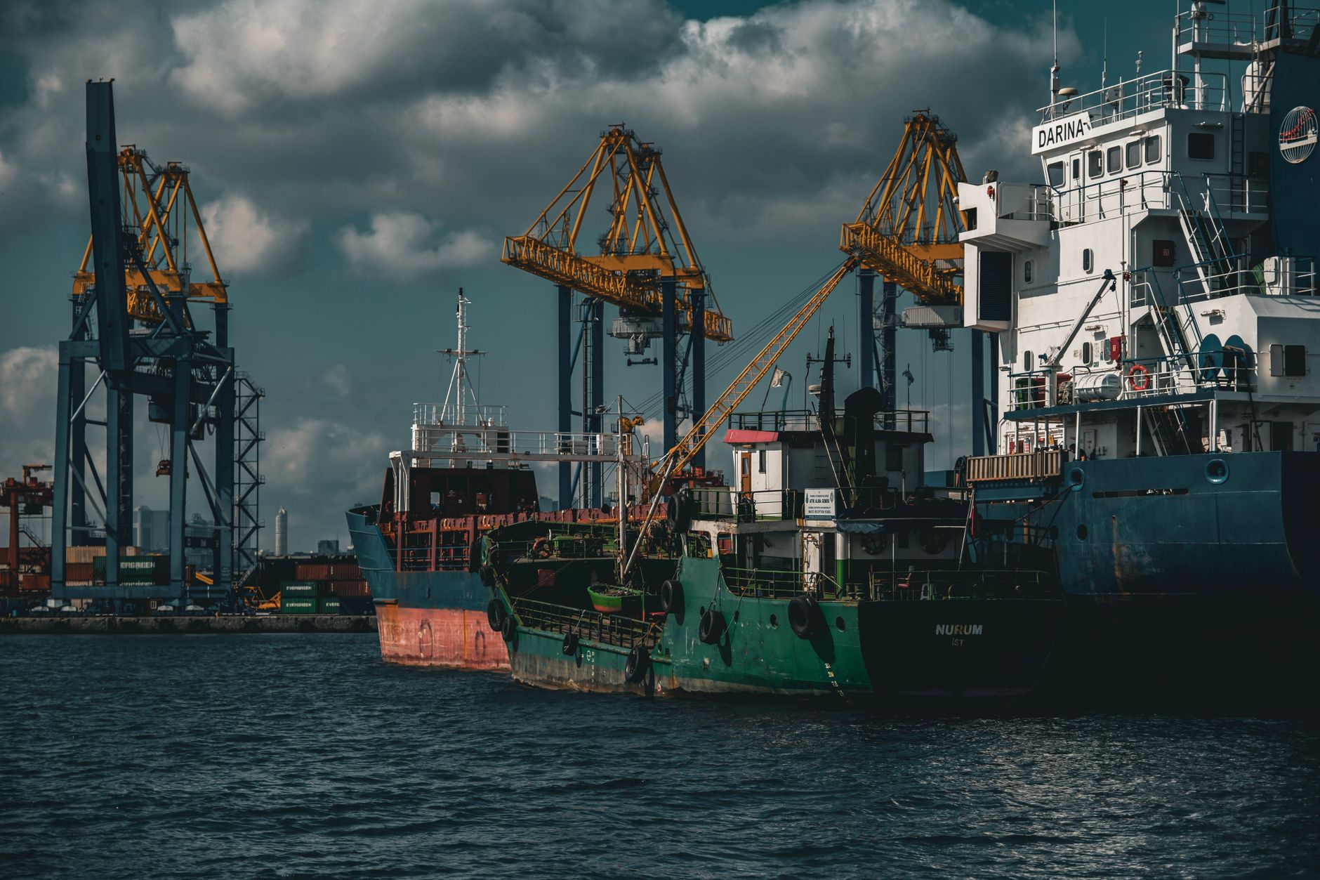 Large cargo ship docked at a commercial shipping port with stacked containers