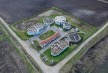 Aerial view of a municipal wastewater treatment facility with large circular clarifier tanks