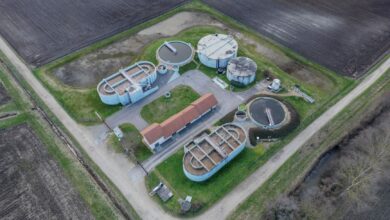 Aerial view of a municipal wastewater treatment facility with large circular clarifier tanks