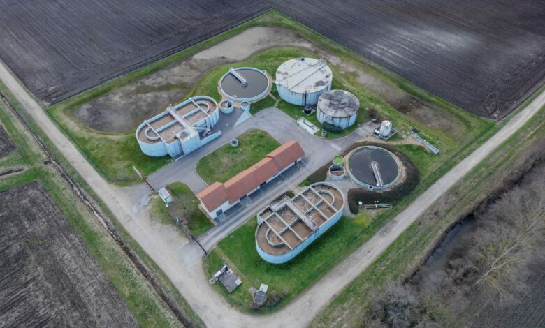 Aerial view of a municipal wastewater treatment facility with large circular clarifier tanks
