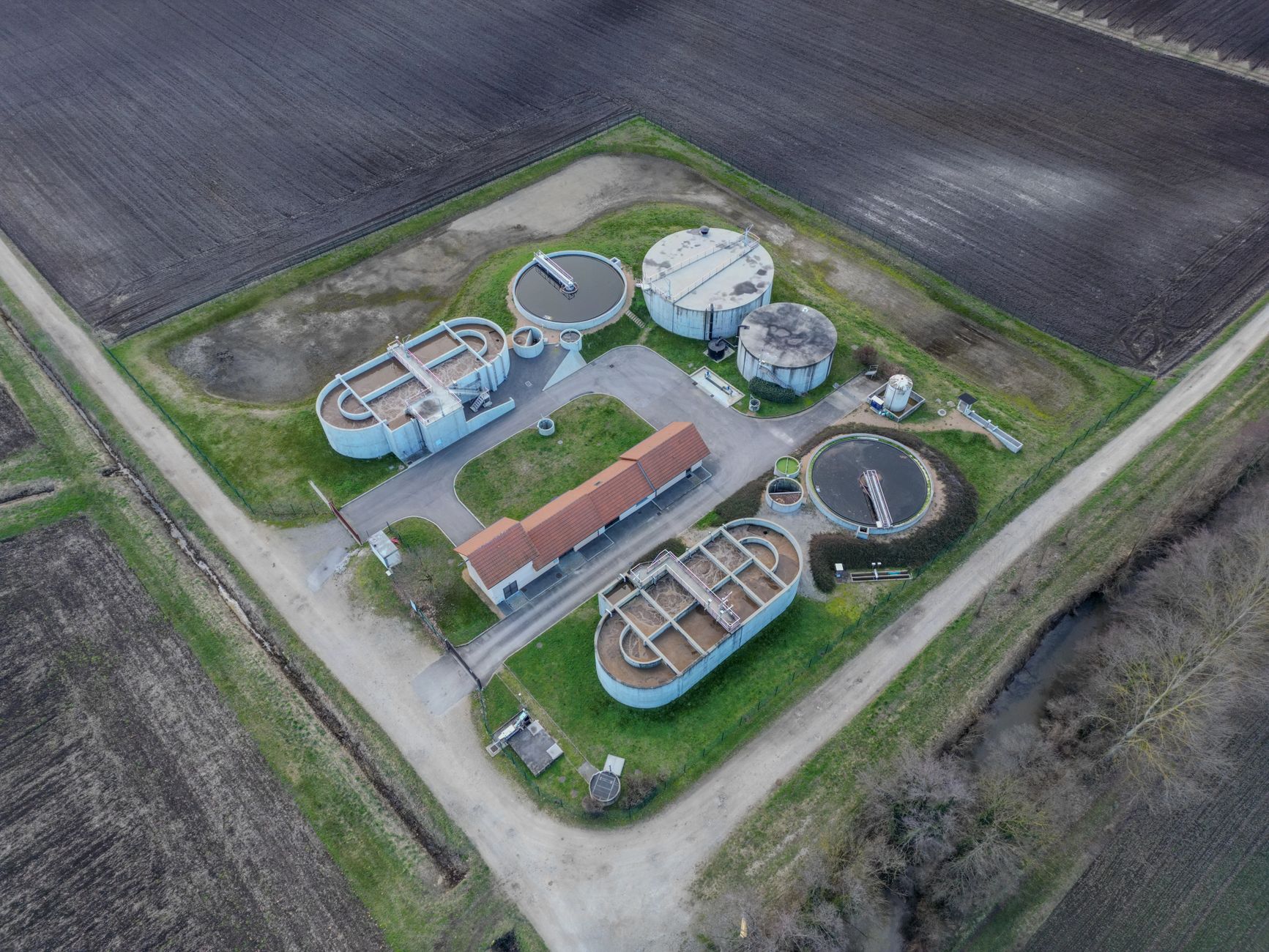 Aerial view of a municipal wastewater treatment facility with large circular clarifier tanks