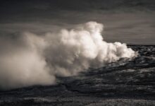 Geothermal power plant with steam rising from vents against a clear sky