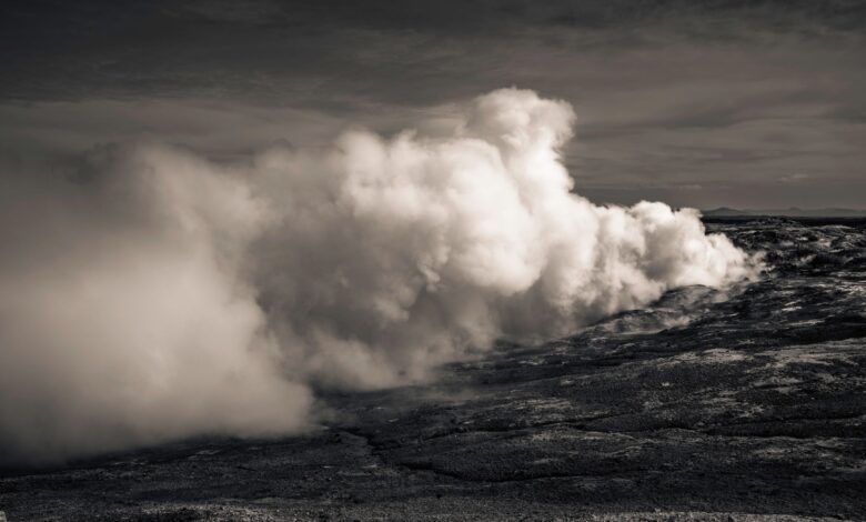 Geothermal power plant with steam rising from vents against a clear sky