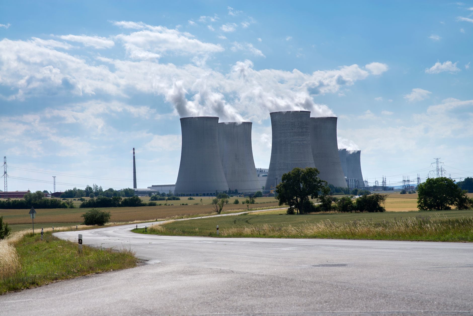 Aerial view of a nuclear power plant with cooling towers reflecting in a river