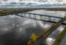 Aerial view of a toll bridge spanning a wide river in an urban corridor