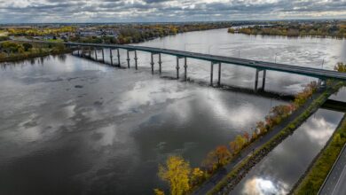 Aerial view of a toll bridge spanning a wide river in an urban corridor