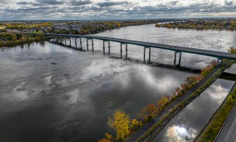 Aerial view of a toll bridge spanning a wide river in an urban corridor