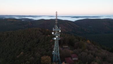 Aerial view of a broadcast radio tower against a blue sky representing wireless spectrum infrastructure
