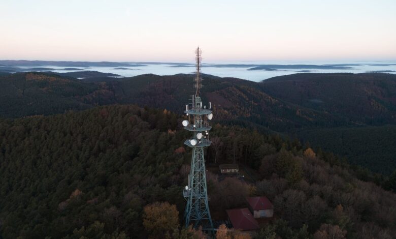 Aerial view of a broadcast radio tower against a blue sky representing wireless spectrum infrastructure