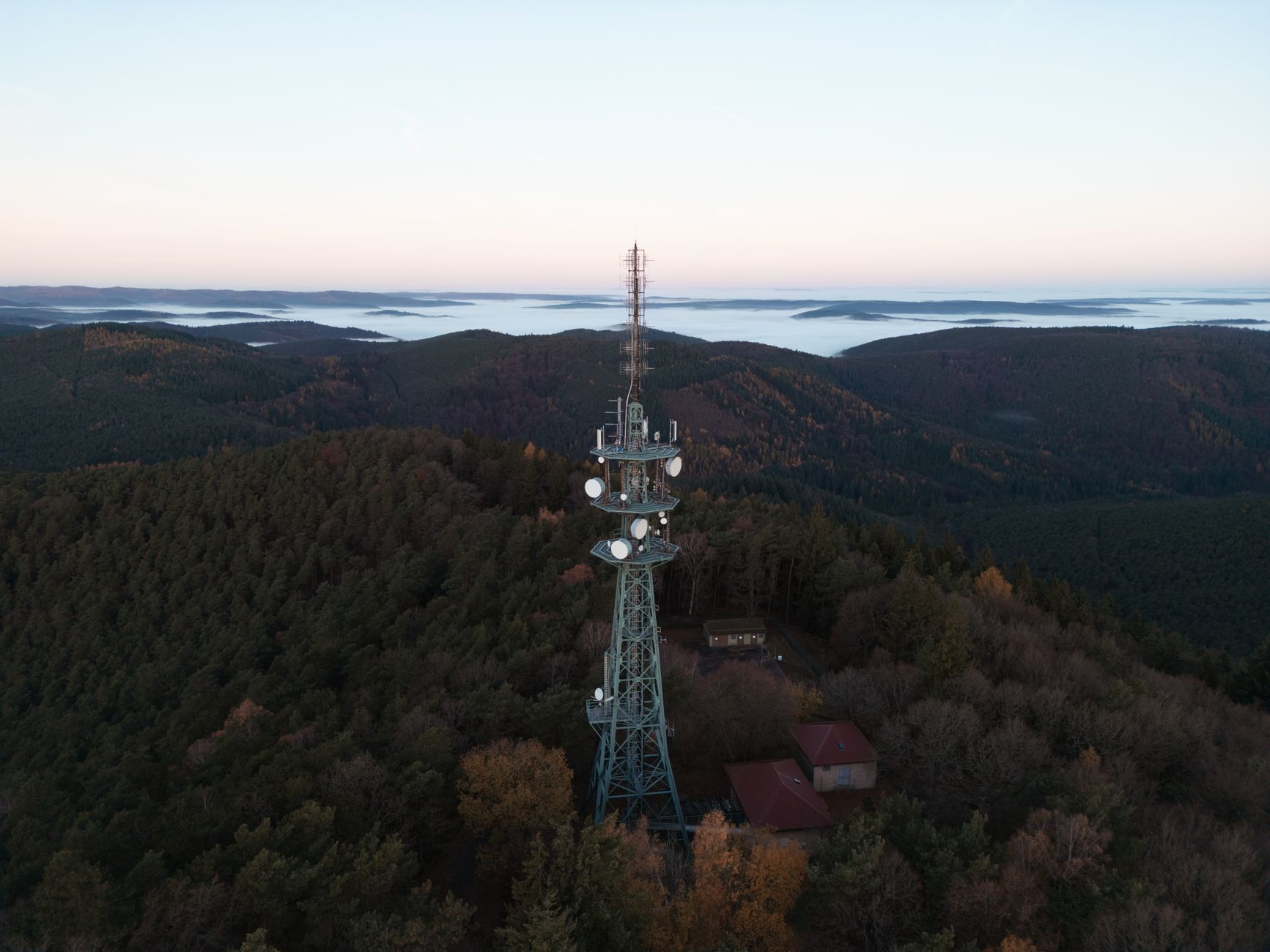 Aerial view of a broadcast radio tower against a blue sky representing wireless spectrum infrastructure