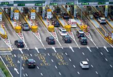Aerial view of a multi-lane toll road with traffic flowing through payment booths