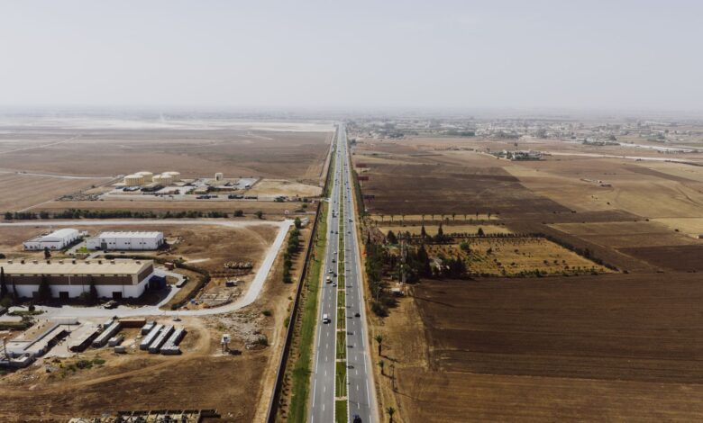 Aerial view of a multi-lane toll expressway with traffic flowing through toll booths