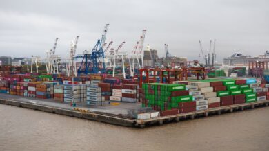 Shipping containers stacked at a busy commercial port terminal