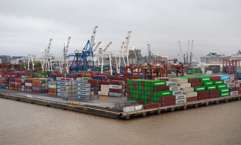 Shipping containers stacked at a busy commercial port terminal