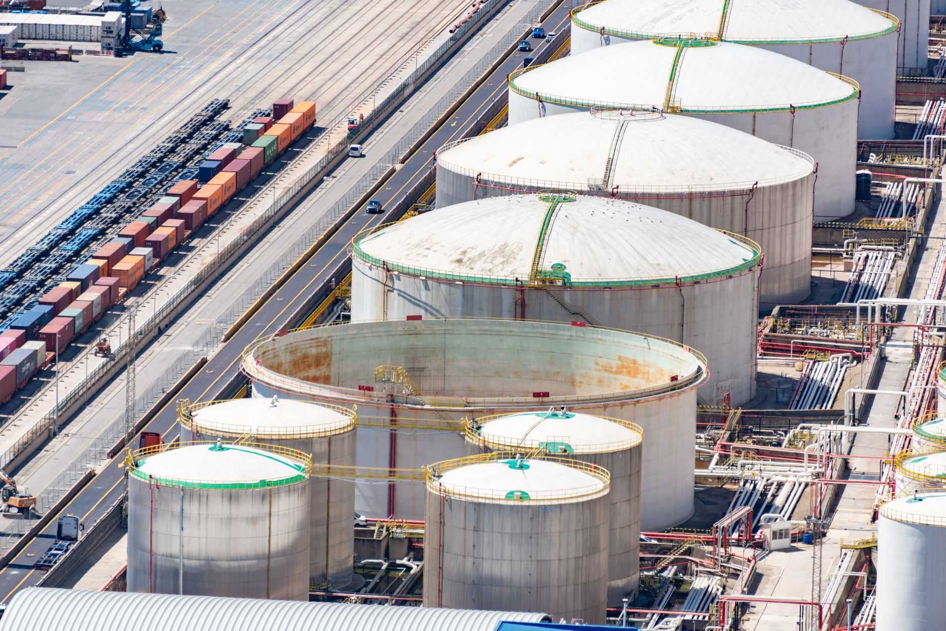Large aviation fuel storage tanks near a commercial airport runway